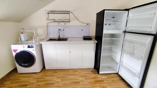 a kitchen with a refrigerator and a washing machine at Khách sạn An An Đà Lạt in Da Lat