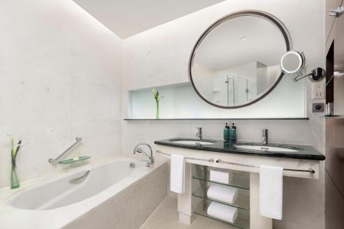 a bathroom with a tub and a sink and a mirror at Pudong Shangri-La Shanghai - With a sweeping view of the Pearl Tower and the historic Bund skyline in Shanghai