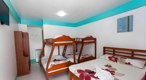 a bedroom with two bunk beds and a blue ceiling at Palm Grove Saud Holiday Complex Hotel in Laoag