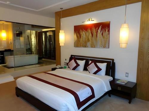 a bedroom with a large bed and a bathroom at BMC Ha Tinh hotel in Ha Tinh