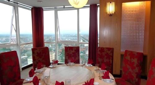 a table with red chairs in a room with a large window at BMC Ha Tinh hotel in Ha Tinh