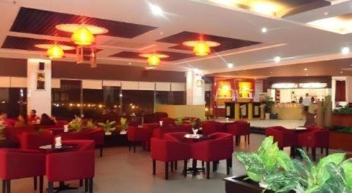 a restaurant with red chairs and tables in a room at BMC Ha Tinh hotel in Ha Tinh