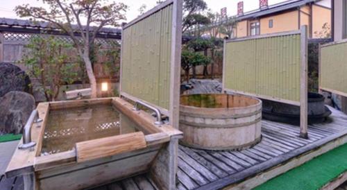 a large wooden deck with a hot tub on it at Nanaironoyu Hotel in Takeo