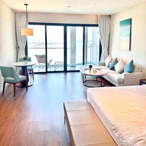 a living room with a bed and a couch and a table at A la carte Residence - high floor in Ha Long