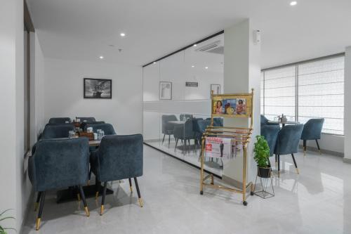 a dining room with chairs and a table and a mirror at Hotel Golden Couch in Badagara