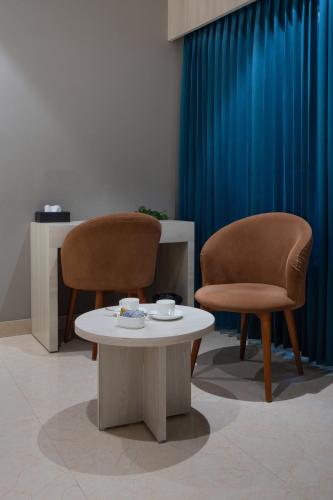 two chairs and a coffee table in a waiting room at Hotel Golden Couch in Badagara