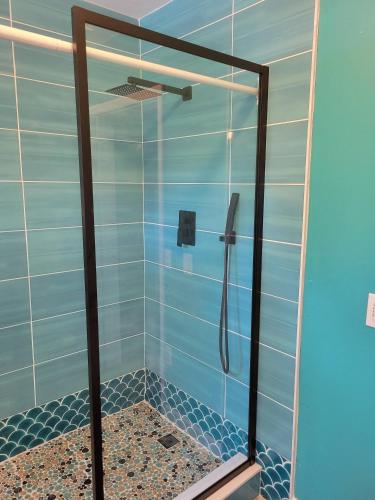 a bathroom with a shower with blue tiles at The Mermaid on the Cotee River in Port Richey