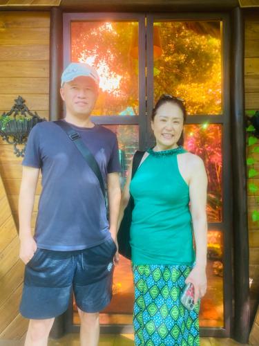 a man and a woman standing in front of a window at Chika's Place River View Udawalawa in Udawalawe