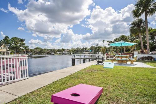 a patio with a table and an umbrella next to the water at The Mermaid on the Cotee River in Port Richey
