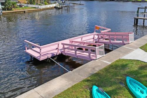 two pink benches sitting on a dock in the water at The Mermaid on the Cotee River in Port Richey