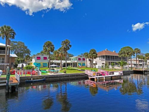 a group of boats docked in a river with buildings at The Mermaid on the Cotee River in Port Richey
