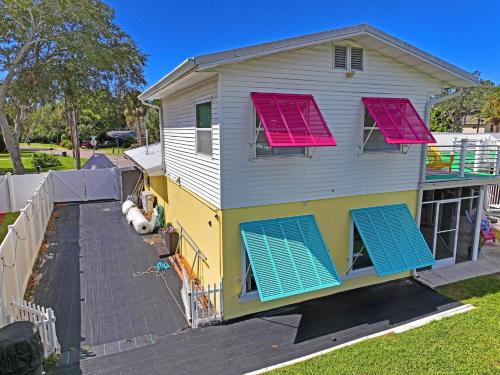 a house with pink and blue shutters on it at The Mermaid on the Cotee River in Port Richey