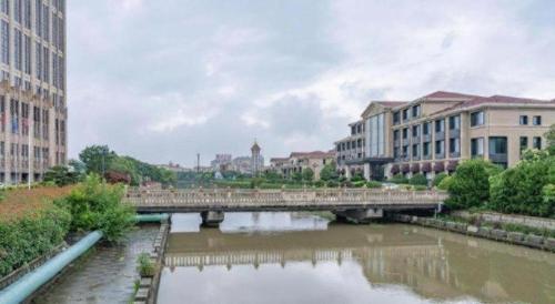 a bridge over a river in a city with buildings at Zhejiang D.H Hotel in Jiaxing