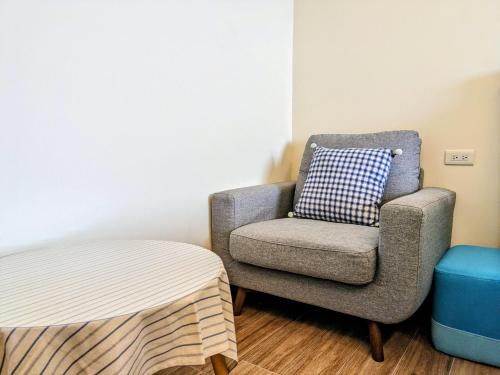 a chair with a pillow and a stool in a room at Yun Dan in Lugu