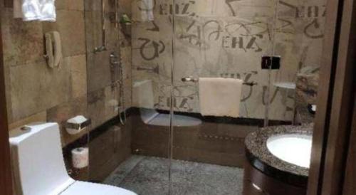 a bathroom with a shower and a toilet and a sink at Jai Alai Hotel in Macau