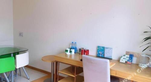 a wooden table with two white chairs in a room at GreenTree Inn Xuancheng Jingxian Wannan First Street Express Hotel in Xuanzhou