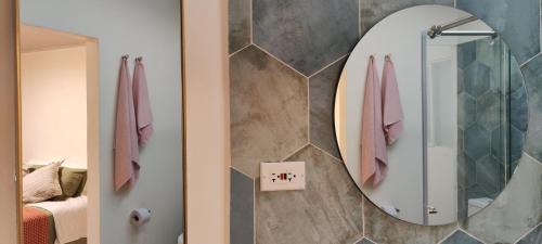 a bathroom with a mirror and a bed at Spacious apartment in Buga, super central in Buga