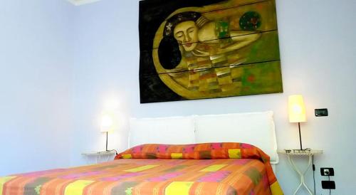 a bedroom with a bed with a painting on the wall at Arcobaleno in Pisa