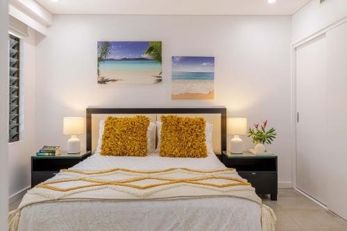 a bedroom with a bed with two nightstands and two lamps at Tranquil Waters 2 Bedroom Apartment in Port Douglas