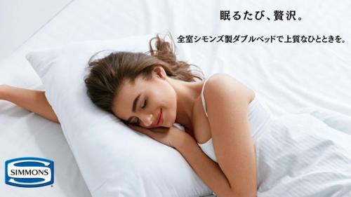 御坊にあるホテルグリーンヒル御坊アネックスの枕付きベッドに横たわる女性