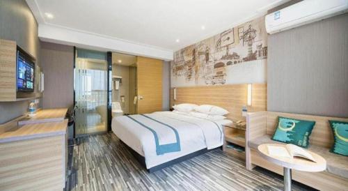 a hotel room with a large bed and a couch at City Comfort Inn Lichuan Railway Station Tenglong Cave in Enshi