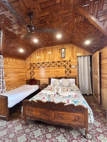 a bedroom with two beds in a room with wooden walls at Houseboat Trambak in Srinagar