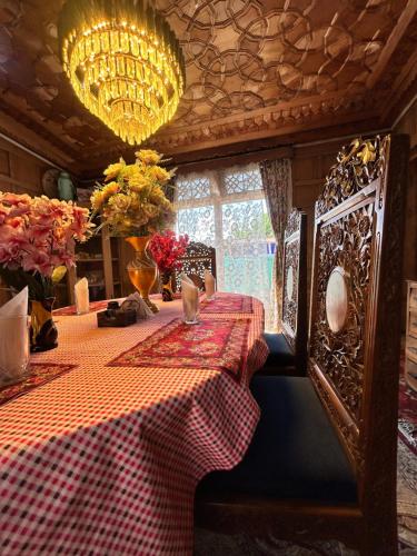 a dining room with a table with a checkered table cloth at Houseboat Trambak in Srinagar