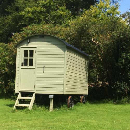 a small shed sitting in the middle of a field at Blackstairs Shepherds Huts in Killedmond