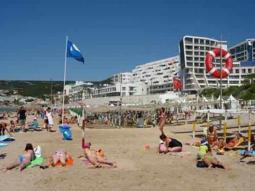 um grupo de pessoas deitadas na praia em Apartment over the Ocean em Sesimbra