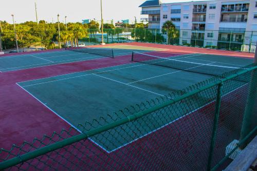 a tennis court with a net in front of a building at The Resort on Cocoa Beach in Cocoa Beach