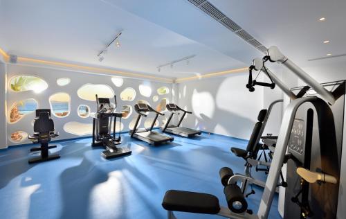a gym with several tread machines in a room at Anax Resort and Spa in Agios Ioannis Mykonos