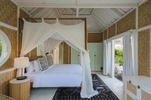 a bedroom with a bed with a canopy at Bodhi Bingin in Uluwatu