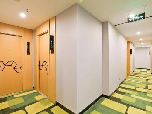 a corridor of an office with graffiti on the walls at Vatica Hotel Hefei Yaohai Longgang Subway Station in Hefei