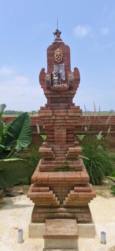 a brick monument with a clock on top of it at Peaceful 2BR House with Rice Field View Near Beach & Local Spots in Mendaya