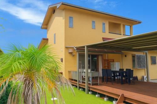 a house with a deck with a table and chairs at 糸島リトリートヴィラ芥屋 in Itoshima
