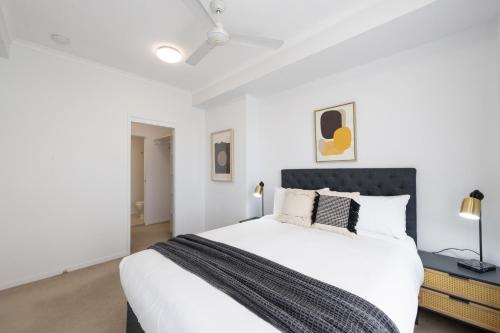 a white bedroom with a large white bed with pillows at Boulevard North Lakes in North Lakes