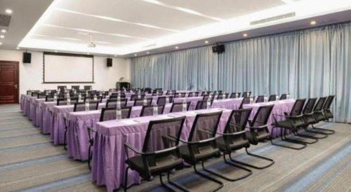 a banquet hall with purple tables and chairs and a screen at Lavande Hotel Zhongshan Xiaolan Taifeng in Jilong