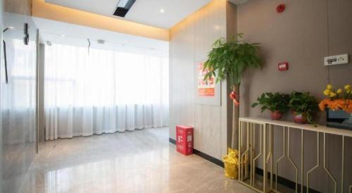 a room with a hallway with a window and plants at Echarm Hotel Changsha Wuyi Square Xiangya Affiliated 1st Provincial Maternity and Child in Changsha