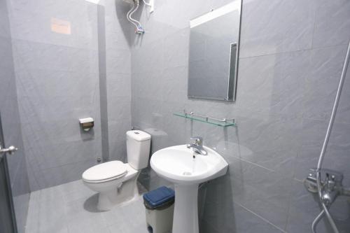 a bathroom with a toilet and a sink and a mirror at Hue Imperial Hostel in Hue