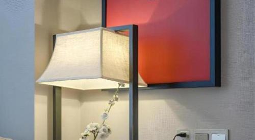 a lamp in the corner of a room with a painting at Echeng Hotel Nanning the Mixc Convention in Nanning