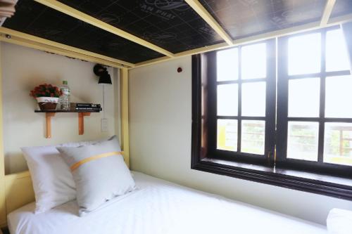 a bedroom with a bed and a window at Hue Imperial Hostel in Hue