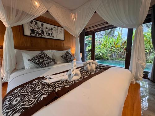 a bedroom with a bed with a woman laying on it at Aura by Nature, Absorb the MAGIC Around in Tegalalang
