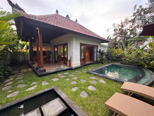 a villa with a swimming pool in front of a house at Aura by Nature, Absorb the MAGIC Around in Tegalalang