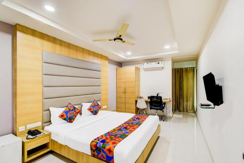 a hotel room with a bed and a desk at FabHotel Prime Veeraj Suites- Nr Skyview10, Lumbini Avenue, Gachibowli in Hyderabad