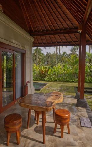 a wooden table and chairs on a patio at Aura by Nature, Absorb the MAGIC Around in Tegalalang