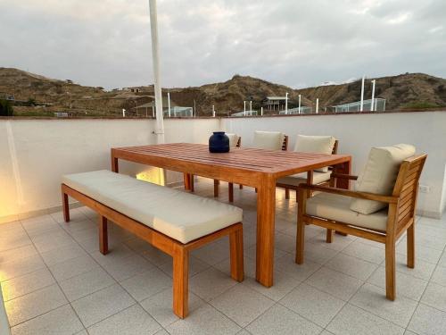 a wooden table and chairs on a balcony at Casa Siete - Playa Zorritos in Zorritos