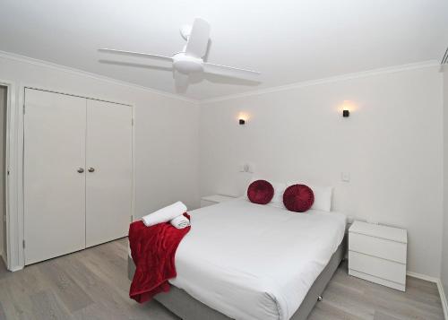 una camera da letto bianca con un letto e un ventilatore a soffitto di Coast Apartments 2 bedroom Hideaway a Torquay