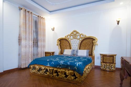 a bedroom with a bed with a blue and golditures at Lưu trú Vạn Lợi in Ho Chi Minh City