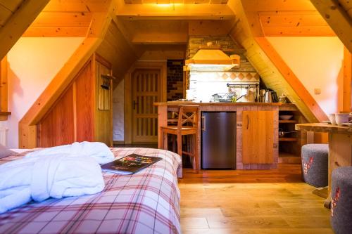 a room with a bed and a kitchen in a cabin at Rezydencja Na Szymoszkowej in Zakopane