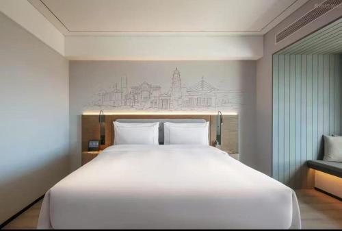 a large white bed in a hotel room at Shantou New Town Huanghe Road Yifei Hotel in Xialian